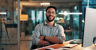Arms crossed, portrait and smile of designer man at desk in office, confident and creative happy employee
